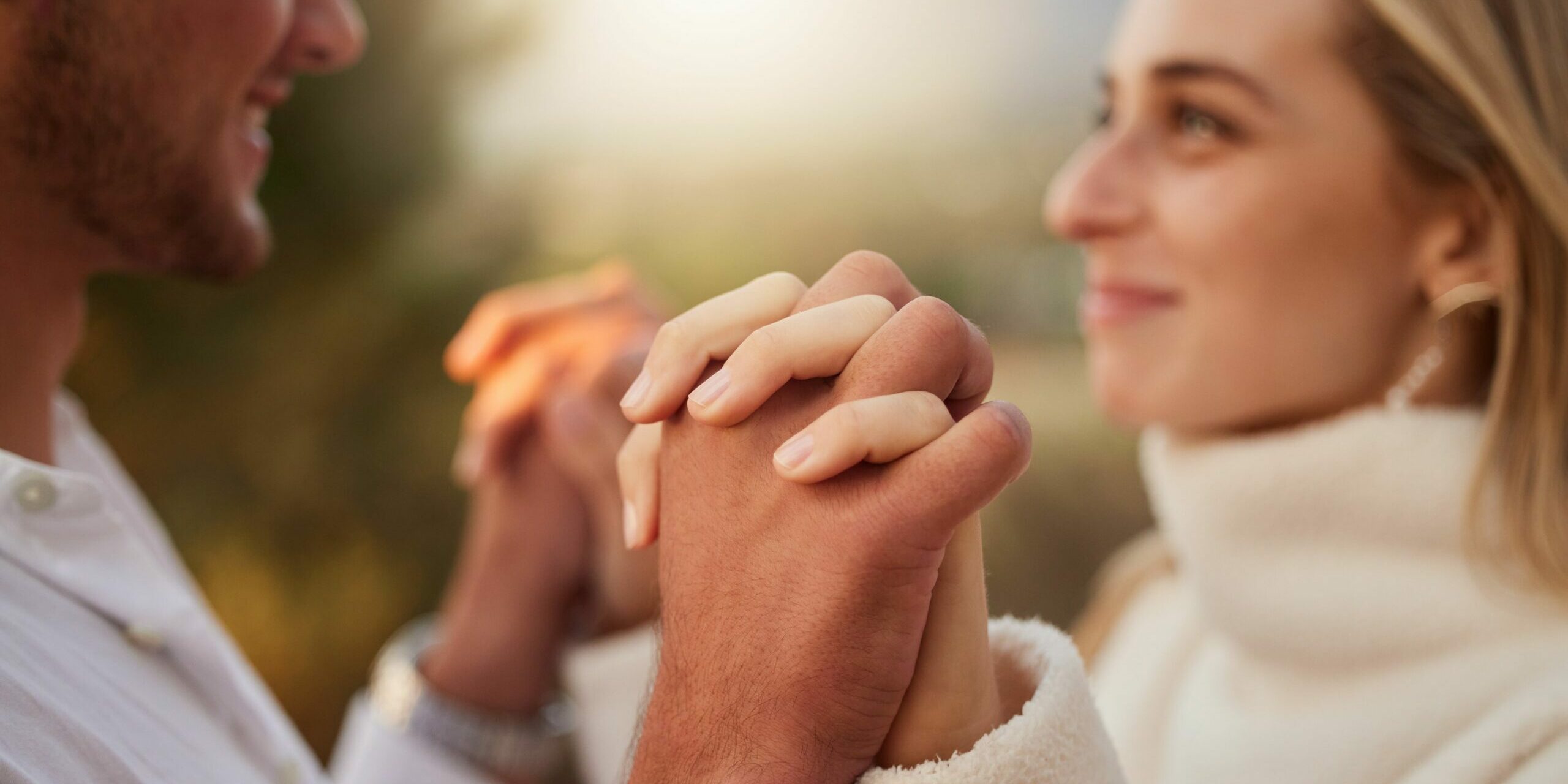 verliebt-in-affaere-beide-verheiratet-wie-geht-es-weiter, ein Paar, das sich bei Sonnenuntergang verliebt an den Händen hält