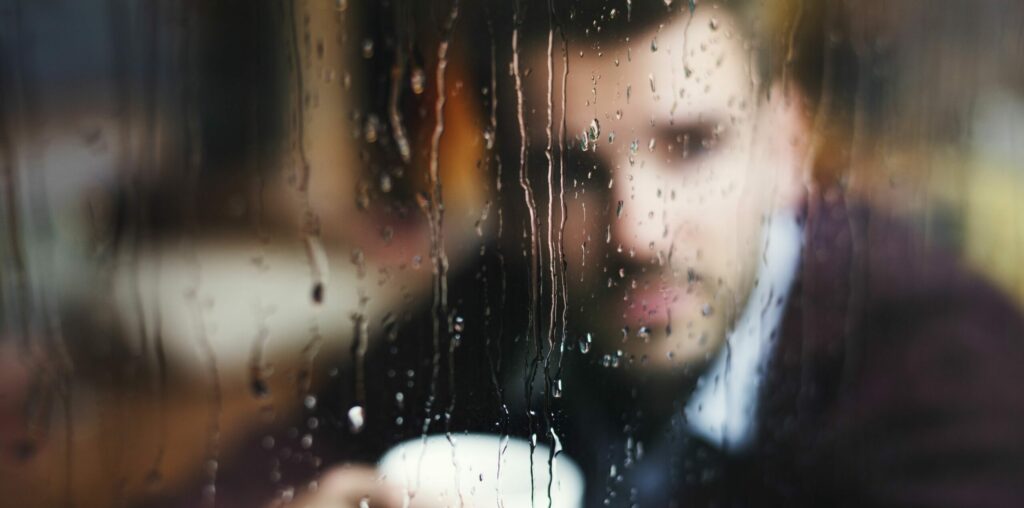 Nachdenklicher Mann, der aus dem Fenster schaut